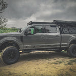 SIDE VIEW OF FORD SUPERDUTY WITH ACS ROOF RACK INSTALLED ALONG WITH ACS FORGED BED RACK WITH A GEARPOD, GEARPPOD DUAL AND ROTOPAX MOUNTED