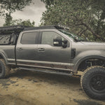 SIDE VIEW OF FORD SUPERDUTY WITH ACS ROOF RACK MOUNTED ALONG WITH ACS FORGED BED RACK AND ACCESSORIES