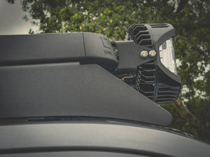 CLOSE UP SIDE VIEW OF LIGHTS ATTACHED TO ACS ROOF RACK SHOWING CORNER CAP WITH LEITNER LOGO