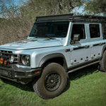 ELDORET BLUE GRENADIER WITH FRONT LOAD BAR AND 3/4 GRENADIER ROOF RACK OUTSIDE ON GRASS