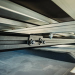 CLOSE UP VIEW OF UNDERNEATH THE ROOFTOP TENT SHOWING ROOF TOP TENT BRACKET 