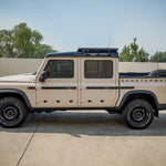 SIDE VIEW GRENADIER QUARTERMASTER TRUCK WITH HALF LENGTH ACS ROOF RACK MOUNTED