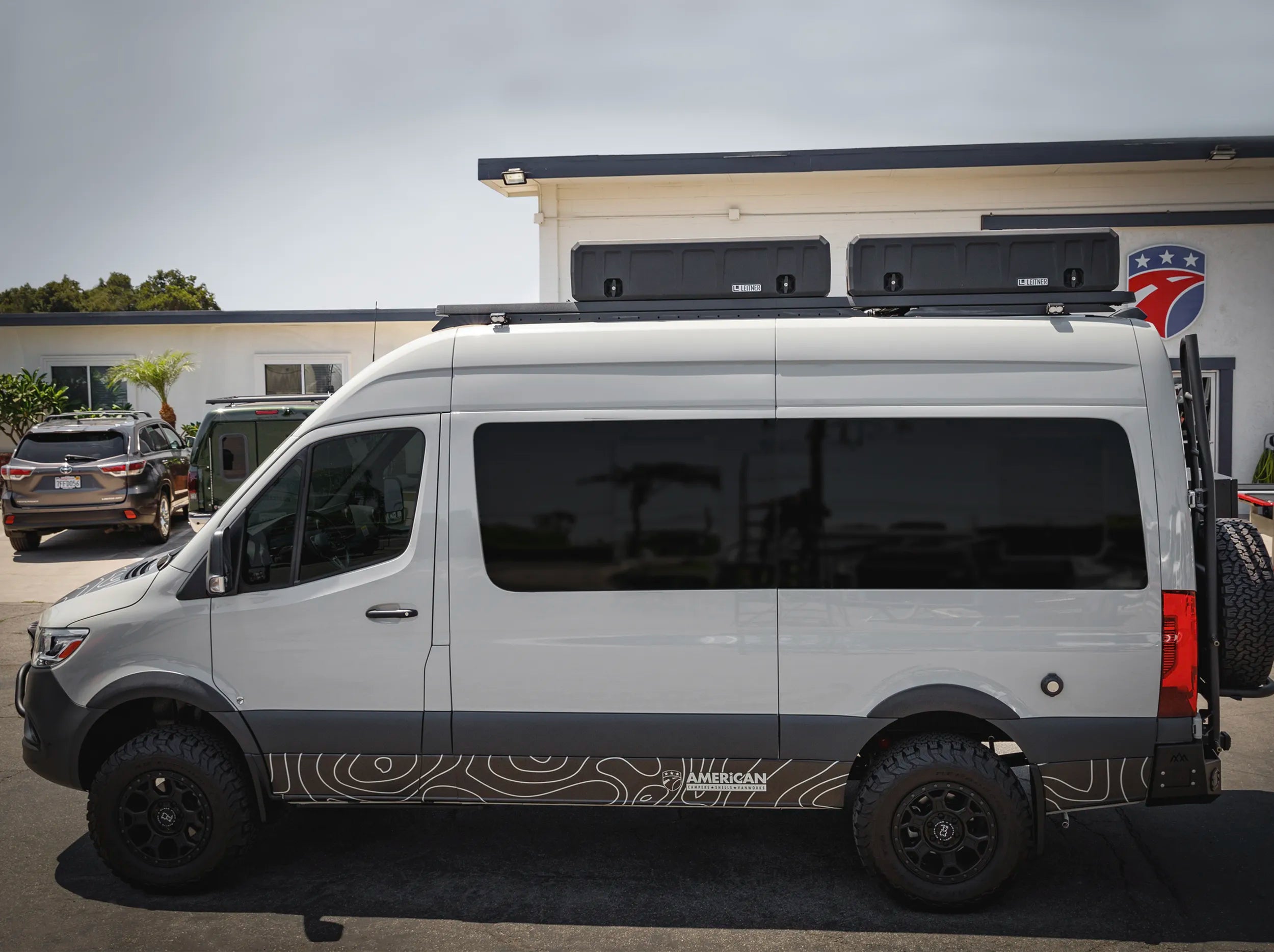 SIDE VIEW OF WHITE SPRINTER BUS AND 2 GEARPOD ROOFS MOUNTED ON ROOF RACK