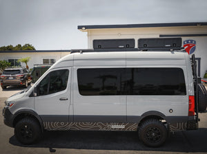 SIDE VIEW OF WHITE SPRINTER BUS AND 2 GEARPOD ROOFS MOUNTED ON ROOF RACK